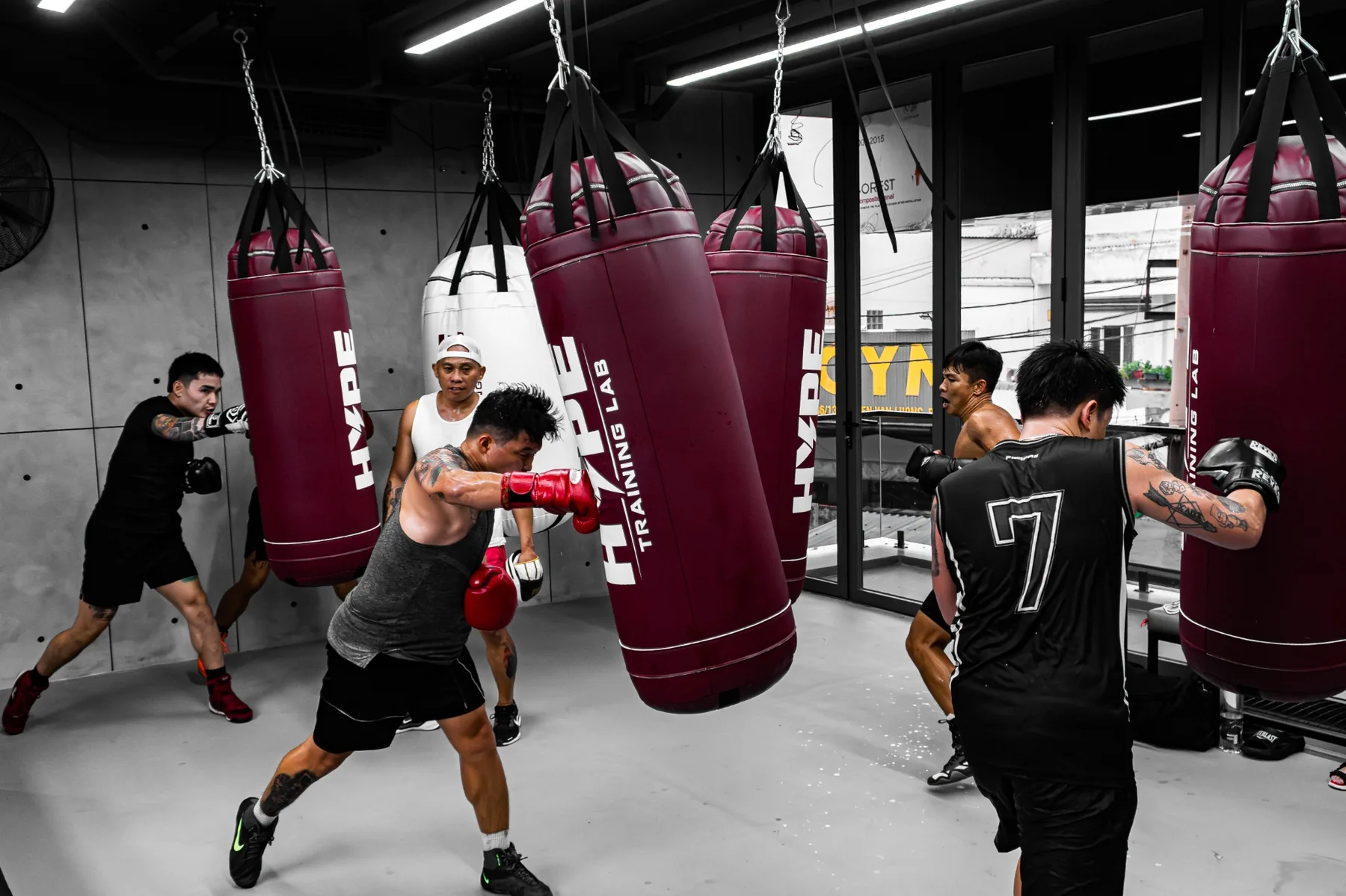 Nhóm học viên đánh bao cát đỏ đô in logo HYPE TRAINING LAB
