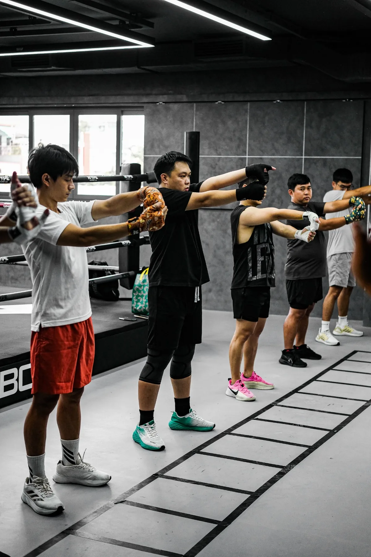 Học viên quấn băng tay khởi động bên thang dây dưới sàn