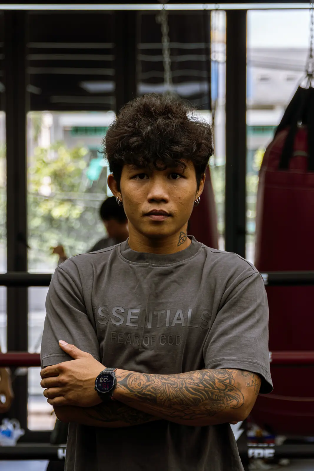 Coach Thông khoanh tay trước võ đài và bao cát tại HYPE