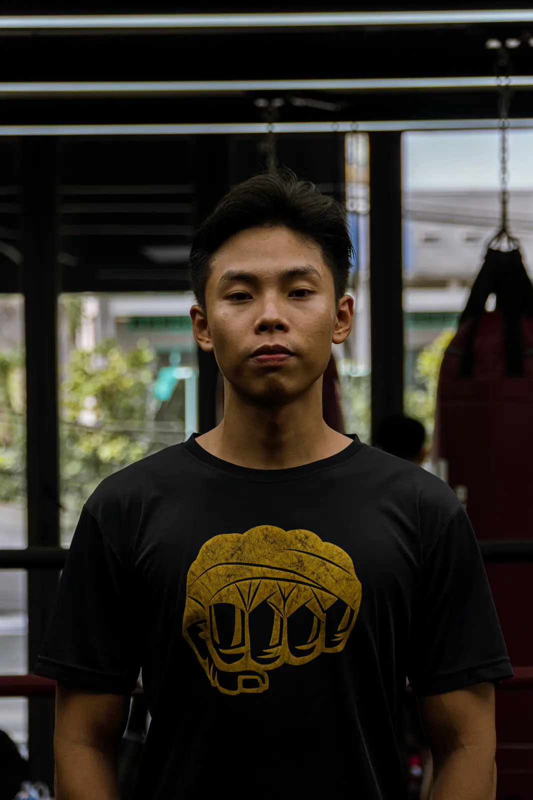Coach Kiên mặc áo in hình nắm đấm, đứng trước võ đài tại HYPE