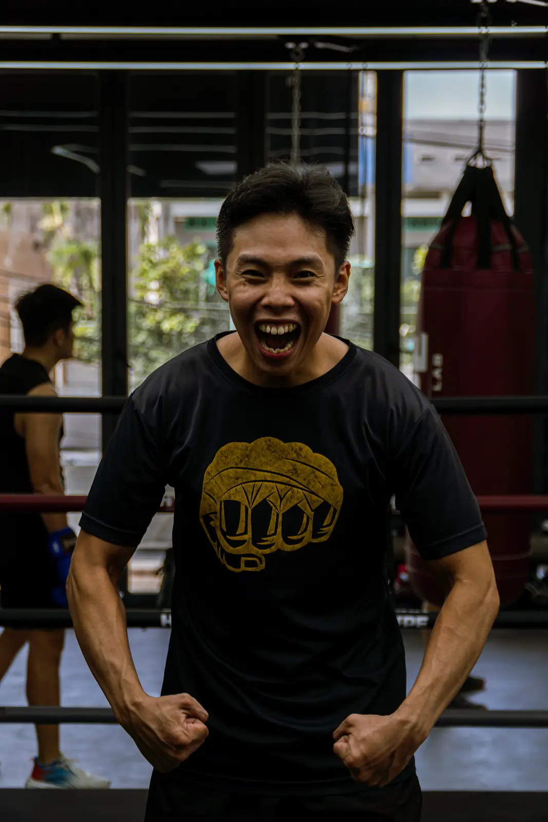Coach Kiên cười lớn, gồng tay cạnh võ đài tại HYPE — khung hình rộng