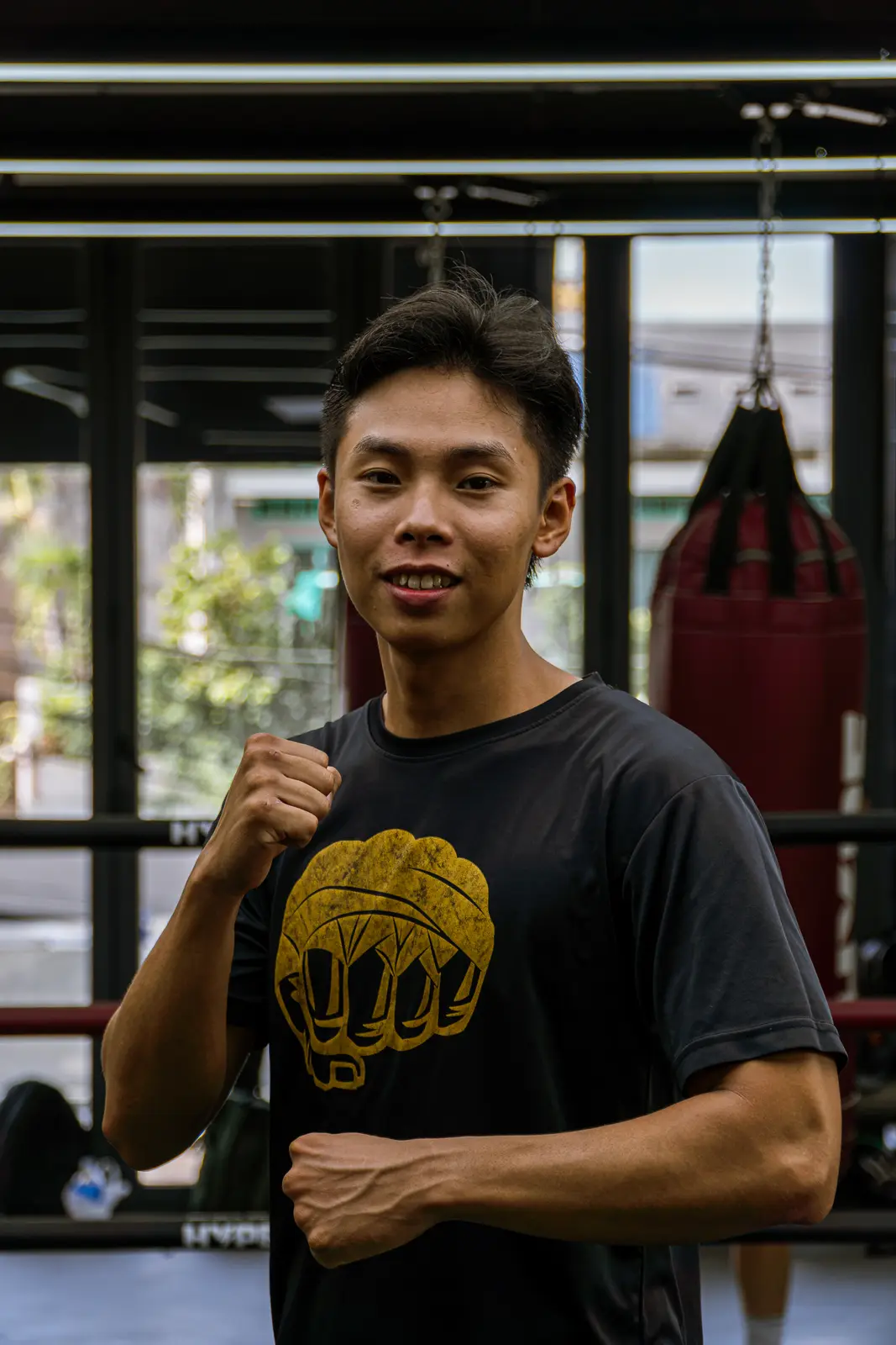 Coach Kiên mỉm cười tạo dáng boxing trước bao cát tại HYPE