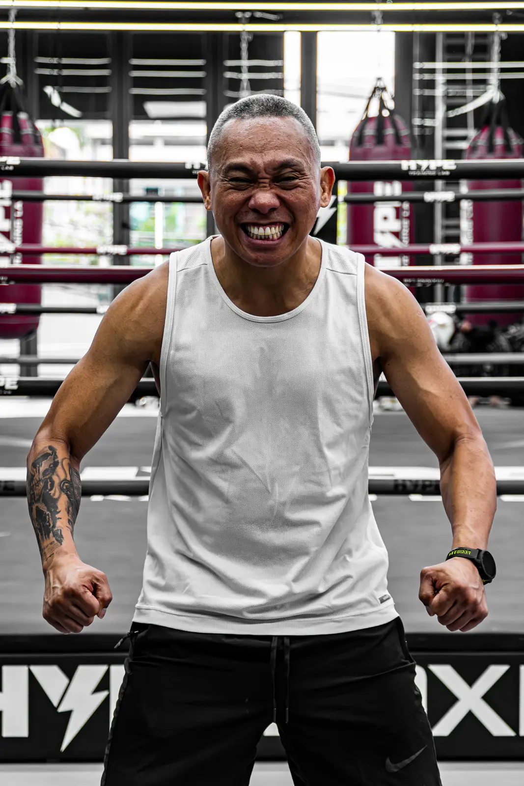 Coach HYPE mặc áo ba lỗ trắng cười tươi, gồng tay trên võ đài tại HYPE