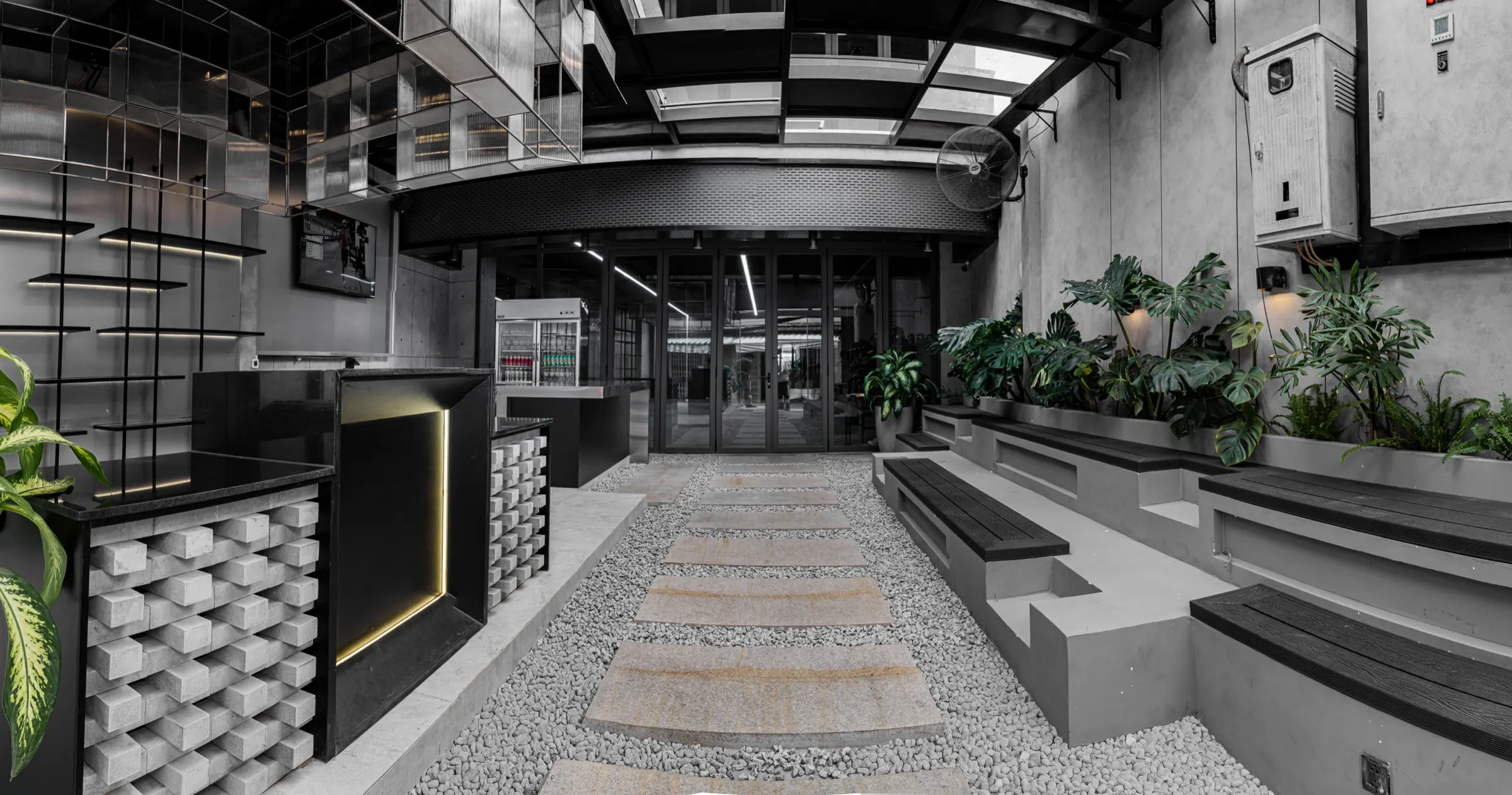Khu lounge tại HYPE — toàn cảnh quầy lễ tân, lối đi đá và cây xanh