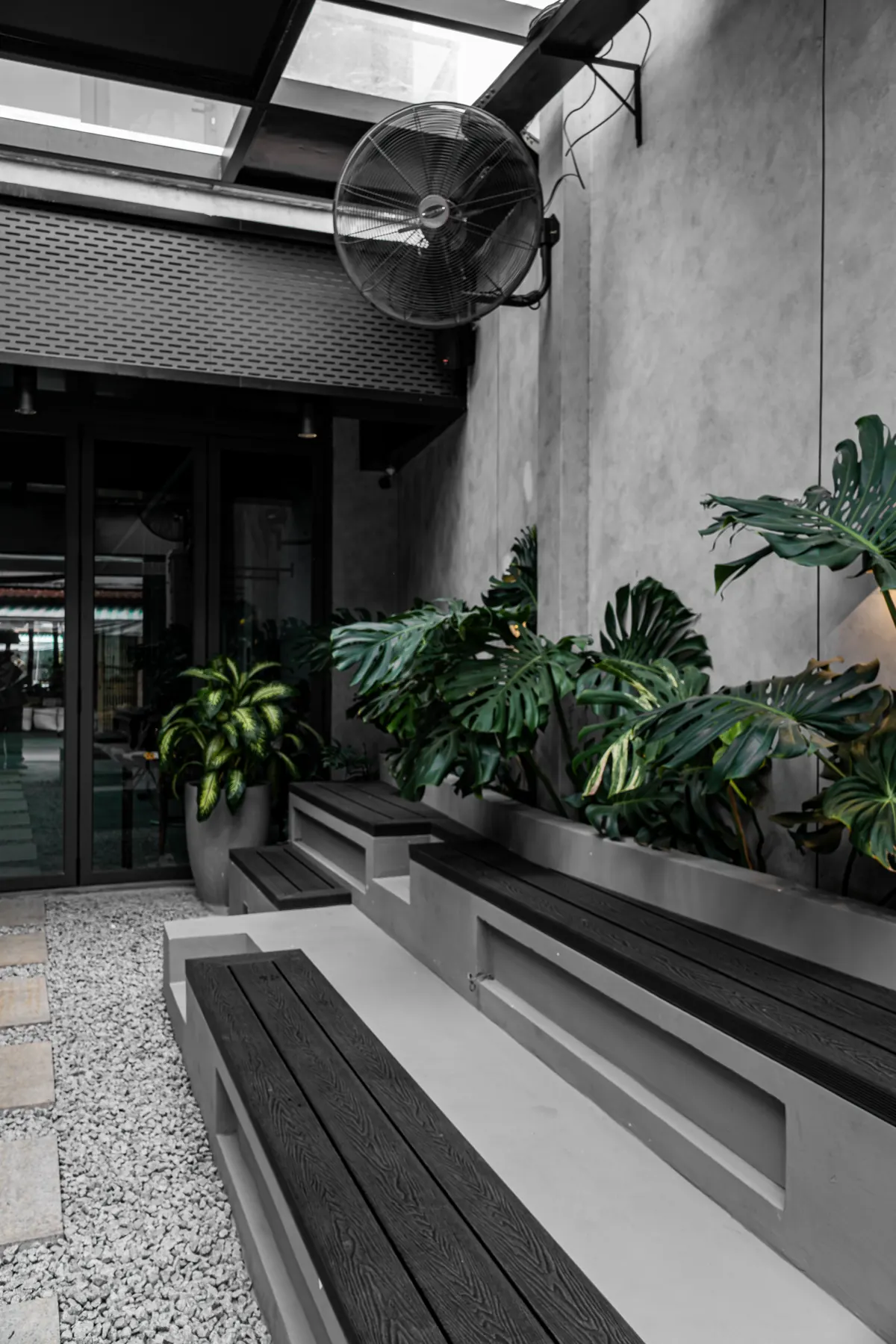 Khu lounge tại HYPE — ghế băng và bồn cây dưới giếng trời