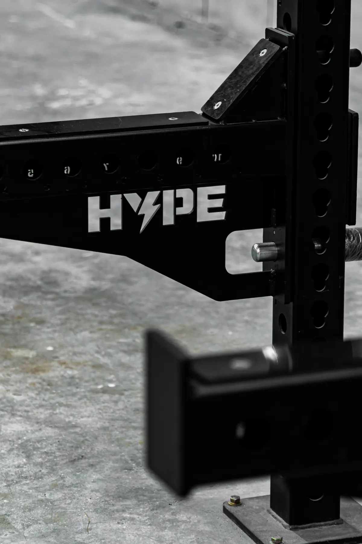Khu Strength tại HYPE — chi tiết tay đỡ giàn tạ in logo HYPE