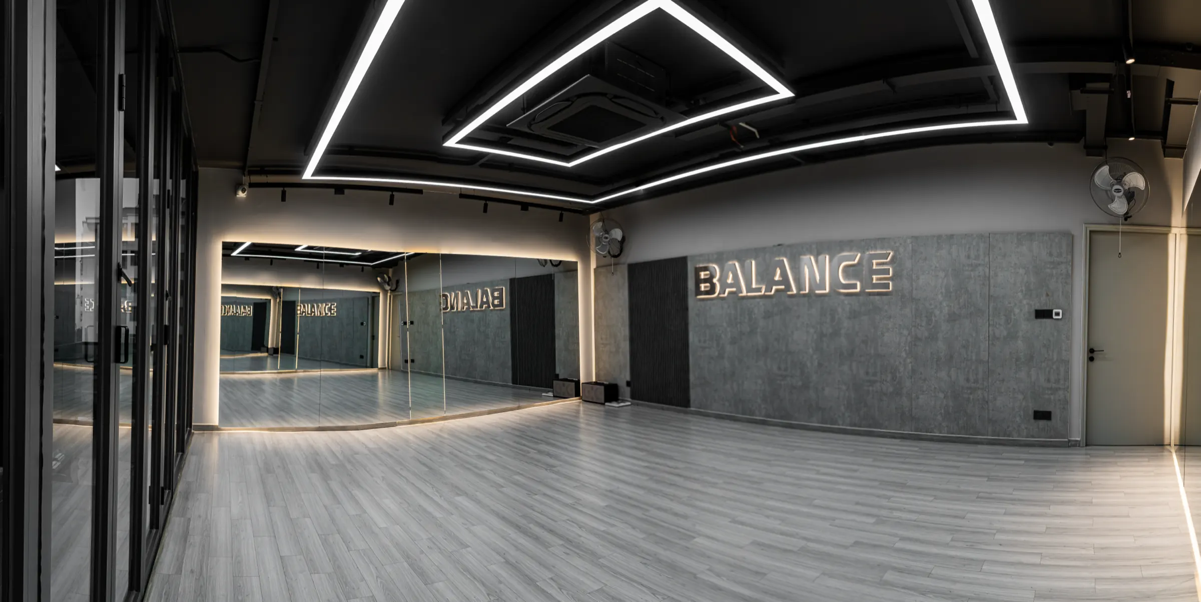 Phòng Balance tại HYPE — sàn gỗ, gương và chữ BALANCE trên tường