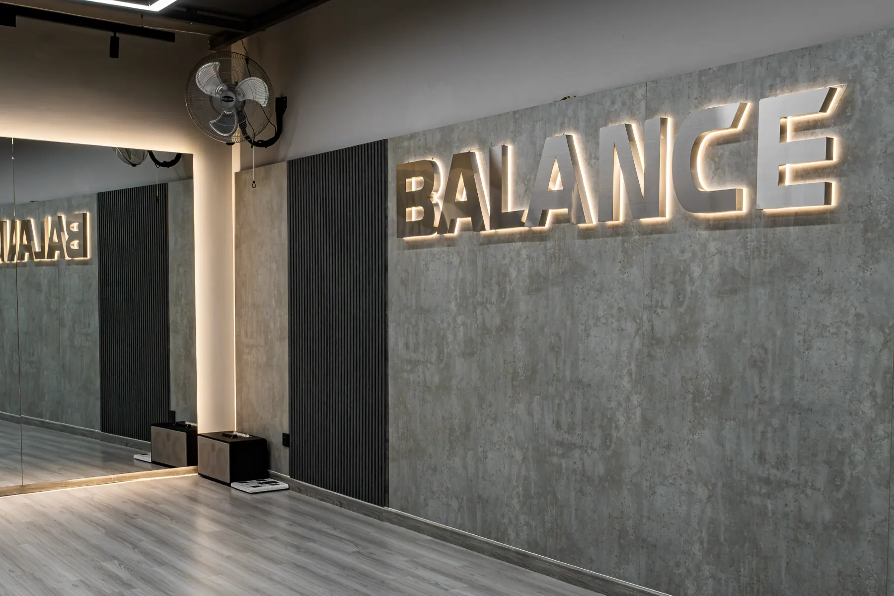 Phòng Balance tại HYPE — chữ BALANCE phát sáng trên tường bê tông